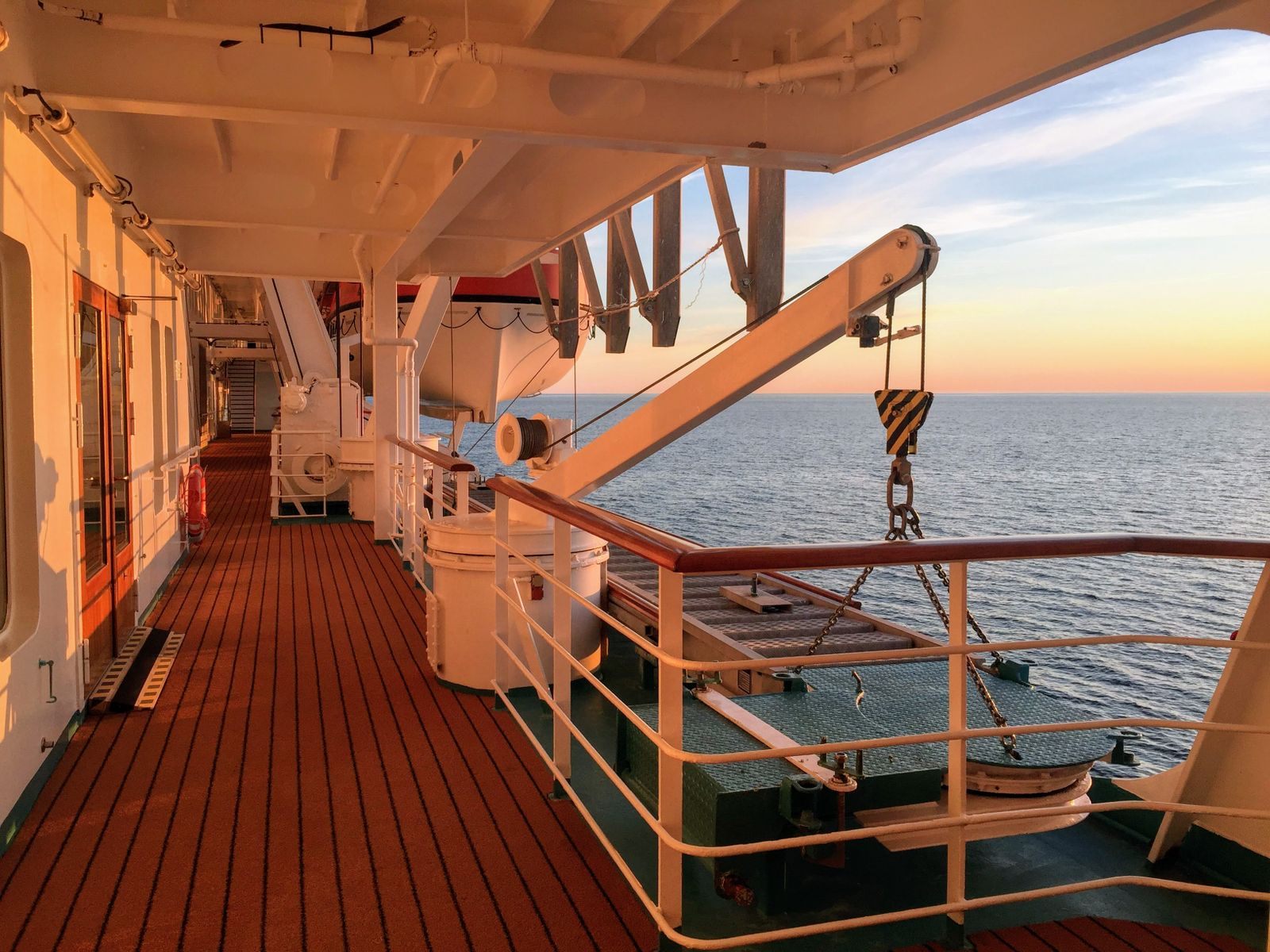 Teak promenade deck of a cruise ship at sunset