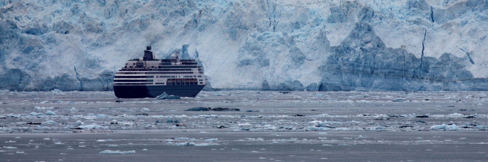 Small cruise ship in front of a tidewater glacier