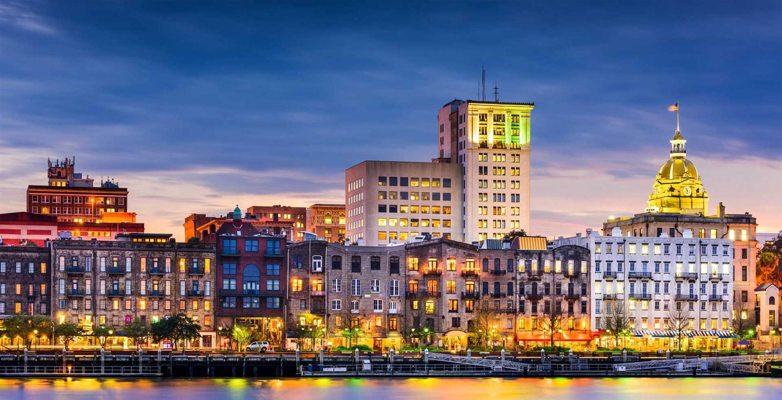 Historic riverfront skyline lit up at dusk